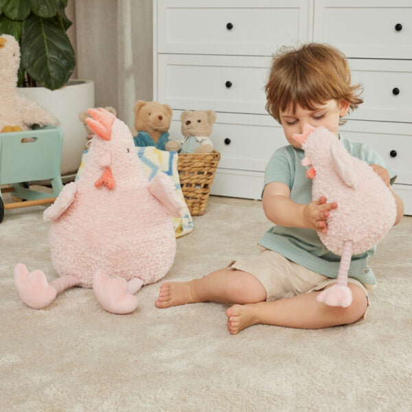 Child playing with two plush toys in a room with teddy bears in the background
