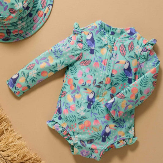 Children's swimsuit with toucan and floral pattern on a beige background