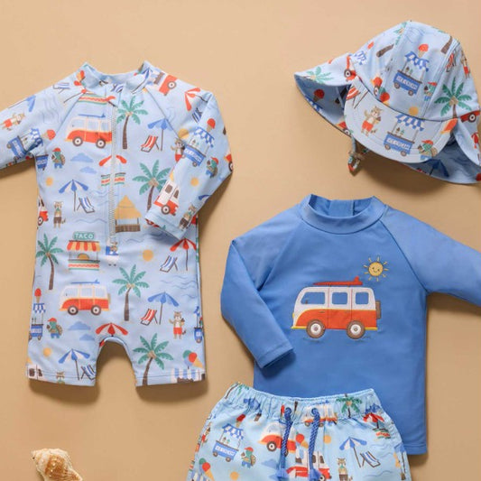 Children's beach outfit set with a swimsuit, shirt, and hat on a beige background